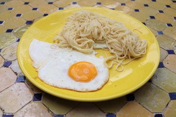 Assiette jaune avec oeuf au plat et pâtes spaghettis - Département du Rhône - France