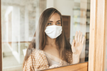 Young woman in medical mask stay isolation at home for self quarantine.