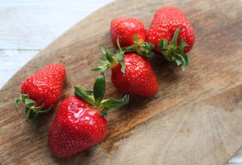 Red fresh strawberries lie on a wooden Board. The concept of fresh and healthy food. The concept of delivering fresh fruit and berries home.