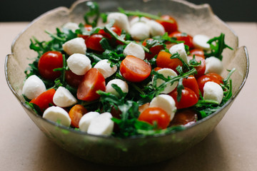 salad of fresh small tomatoes, arugula leaves and cheese