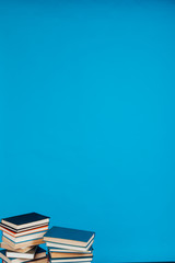 lots of stacks of educational books to teach in the school library on a blue background