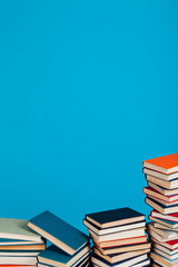 lots of stacks of educational books to teach in the school library on a blue background