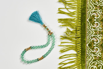 Islamic praying carpet nd praying beads on white