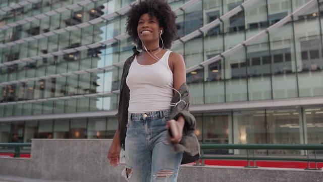 happy young attractive girl spinning smiling listening to music on the phone