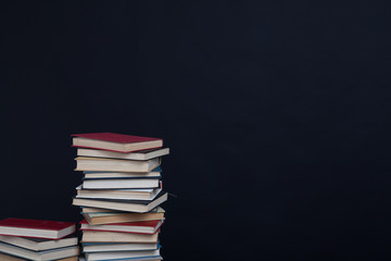 lots of stacks of educational books to teach at the college library on a black background