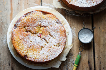 Orange cake with raspberries and rhubarb cut into pieces 