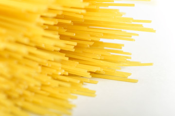 Long yellow spaghetti pasta food ingredient. Uncooked dry macaroni. Thin raw noodle. Cereal wheat product for delicious gourmet cooking. A useful source of carbohydrates. Healthy italian pasta.
