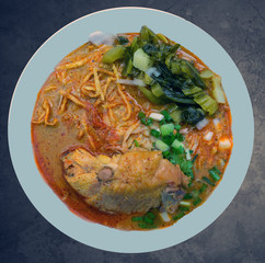 Khao Sawy chicken (Northern Thai Noodle Curry Soup) on the dark  background. Top view.
