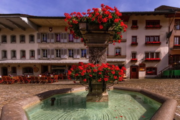 Fountain in Gruyere village in Fribourg canton by beautiful day, Switzerland