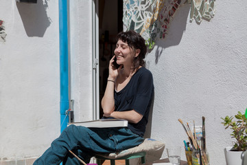 A young woman working at home and using her mobile phone