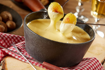 Dipping grilled baby potatoes into a cheese fondue