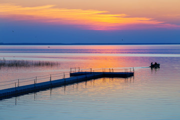 Fototapeta na wymiar summer sunset on lake with boat