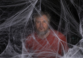 Obraz premium man in a white spider web on a black background