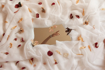 girl's hand with flower petals on a white background
