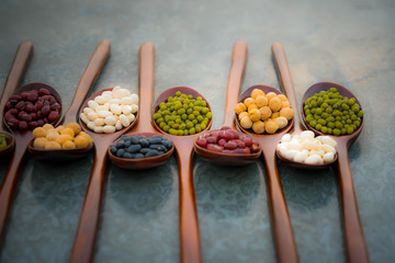 Collection of bean in wooden spoons .dried legumes in wooden spoons place on the table  