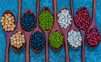 Collection of bean in wooden spoons .dried legumes in wooden spoons place on the table  