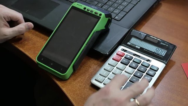 The man calculates the amount payable on the calculator, and then pays the amount with a credit card for the purchase through the terminal while at home via the Internet.
