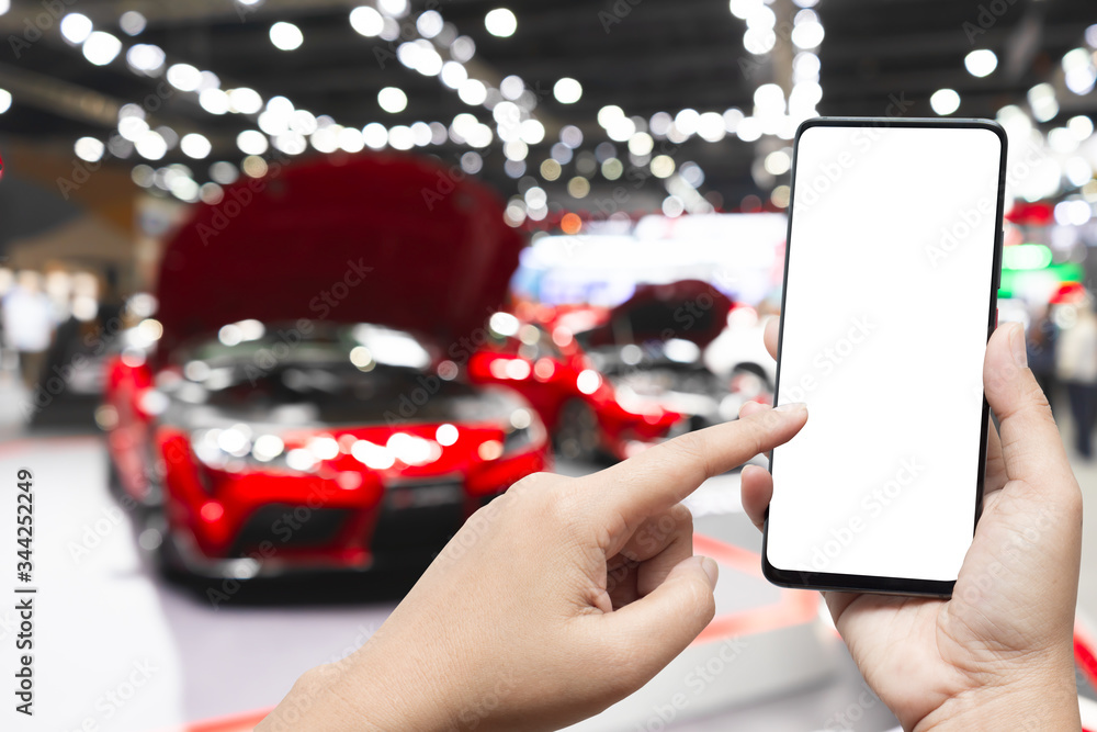 Poster mockup image of hand holding blank screen mobile and pointing to smart phone with blurred background