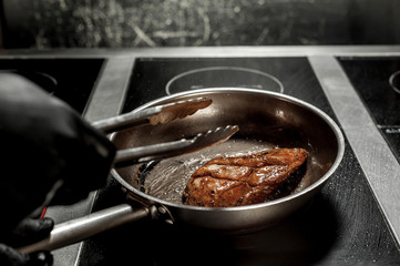 cooking chicken in a pan in the kitchen
