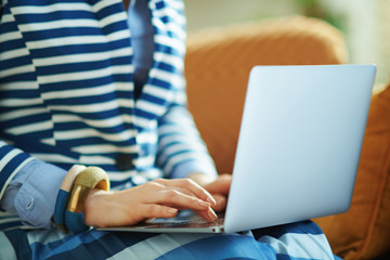 woman using internet on laptop while sitting on sofa