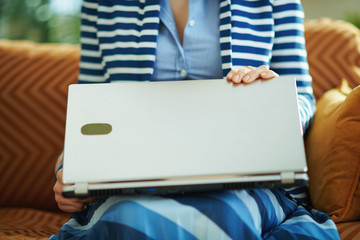 female in living room in sunny day and closing laptop
