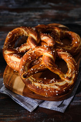 Freshly baked homemade soft pretzel with salt on wooden table. Perfect for Octoberfest.