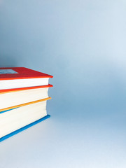 Books. A lot of books with bright covers in one pile isolated on blue background