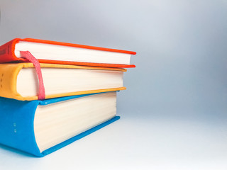 Books. A lot of books with bright covers in one pile isolated on blue background