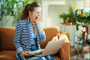 stressed stylish housewife in modern house in sunny day yawing