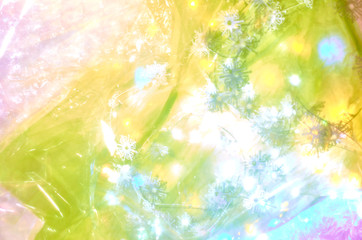 Multicolored snowflake shapes and lights under multicolored plastic