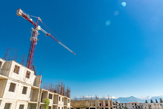 Tower crane, red against the sky and mountains