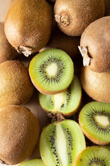 Ripe juicy kiwi fruits closeup. Whole and cut half of kiwifruits. Vertical shot, top view. Healthy organic food concept