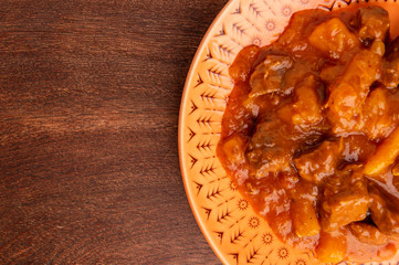 plate with cooked cassava and meat on wooden table