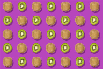 Sequence of a colorful pattern of cut and whole kiwis on a purple background. Zenithal top view.