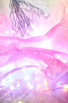Pink materials with Christmas lights and branch