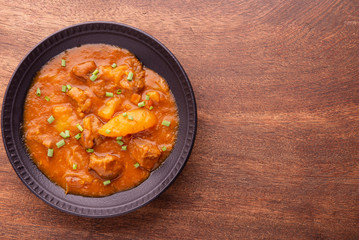 plate with cooked cassava and meat on wooden table