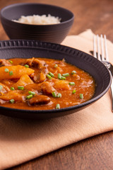 plate with cooked cassava and meat on wooden table