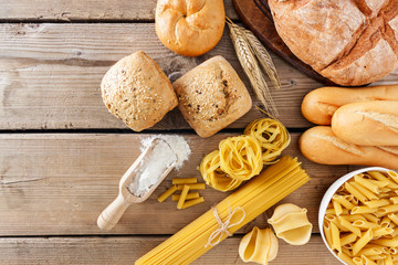 Fototapeta premium Breads and different types of pasta on a wooden background, copy space.