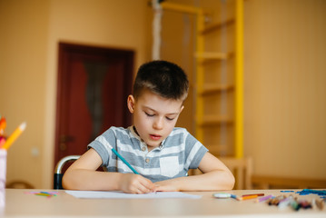 A school-age boy does homework at home. Training at school
