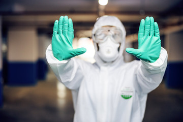 Closeup of man in sterile uniform holding hands as stop sign. Protection from covid-19 / corona...