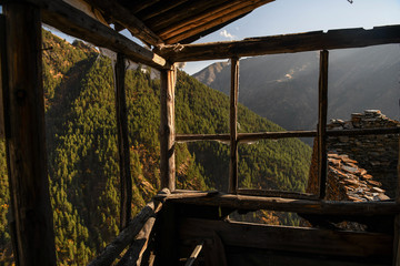 View of the mountains through a wooden window frame in the abandoned village of Kvavlo