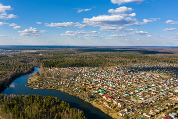 A panorama of the village of Gorino and the Kharinka River from a bird's eye view on a spring sunny day.