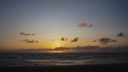 Fototapeta na wymiar Coucher de soleil et ligne de cumulus en arrière-plan, au loin. Très bel horizon.