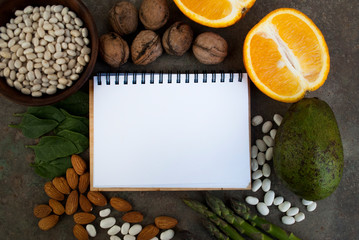 Foods high in vitamin B9. Healthy foods, sources of folic acid. Blank notebook. Top view with copy space. Diet is necessary for pregnant and lactating mothers. Vegetarian food set.