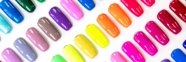 Multicolored nail Polish samples on a white background. Beauty banner. Trendy open composition, pattern. Nail varnish. Top view, flat lay, layout. Fashion, style. Summer manicure. Cosmetic products.