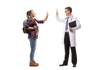 Fototapeta premium Female student gesturing high-five with a male doctor