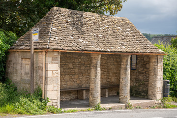 Cotswold stone bus shelter in the Cotswold village of Uley, Gloucestershire, United Kingdom