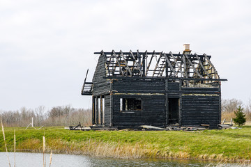 Fototapeta na wymiar burnt down two storey wooden house in rural area