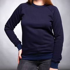 dark blue plain sweatshirt dressed on a girl on a light background. Vertical orientation. - obrazy, fototapety, plakaty