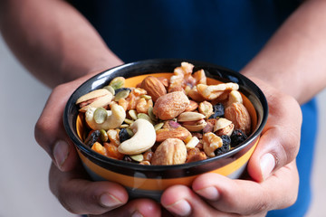 Man hand holding a bowl of Mixed nuts 